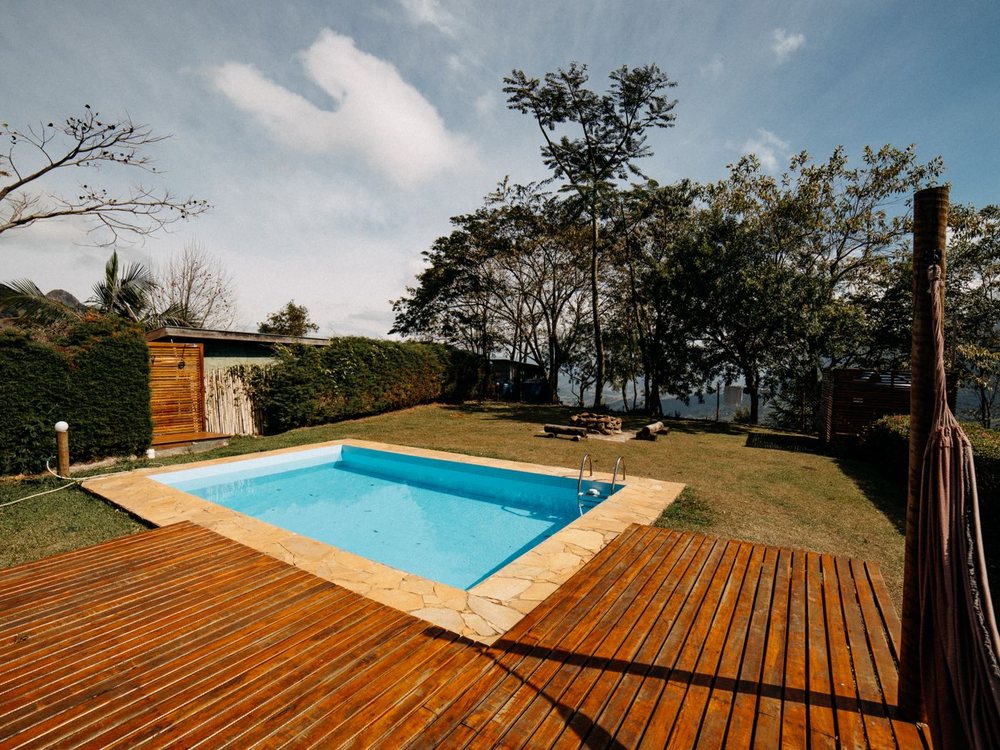 A rich stained hardwood deck wrapping around a pool