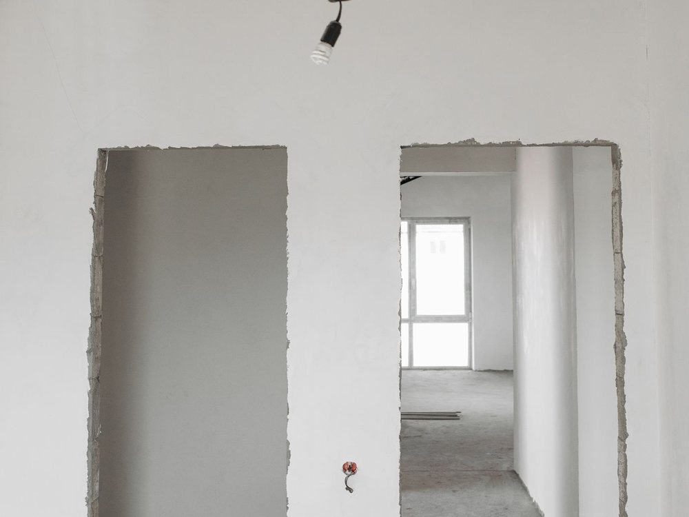 Bare drywall walls and framed doorways in a room ready for finishing