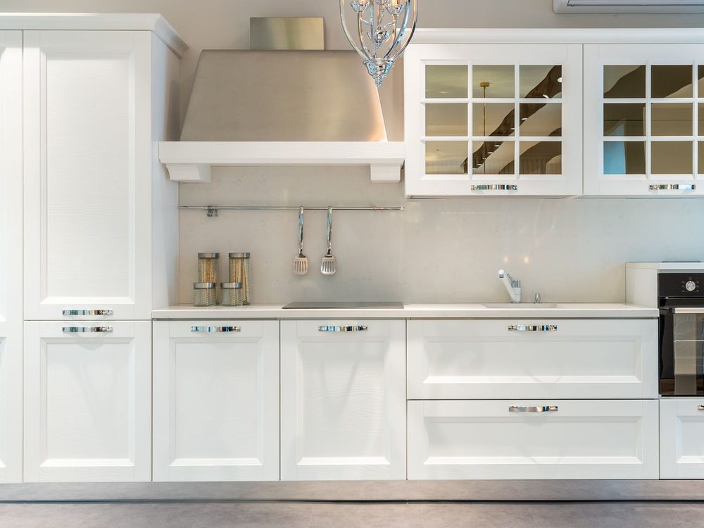 Kitchen with freshly painted white shaker cabinetry and trim